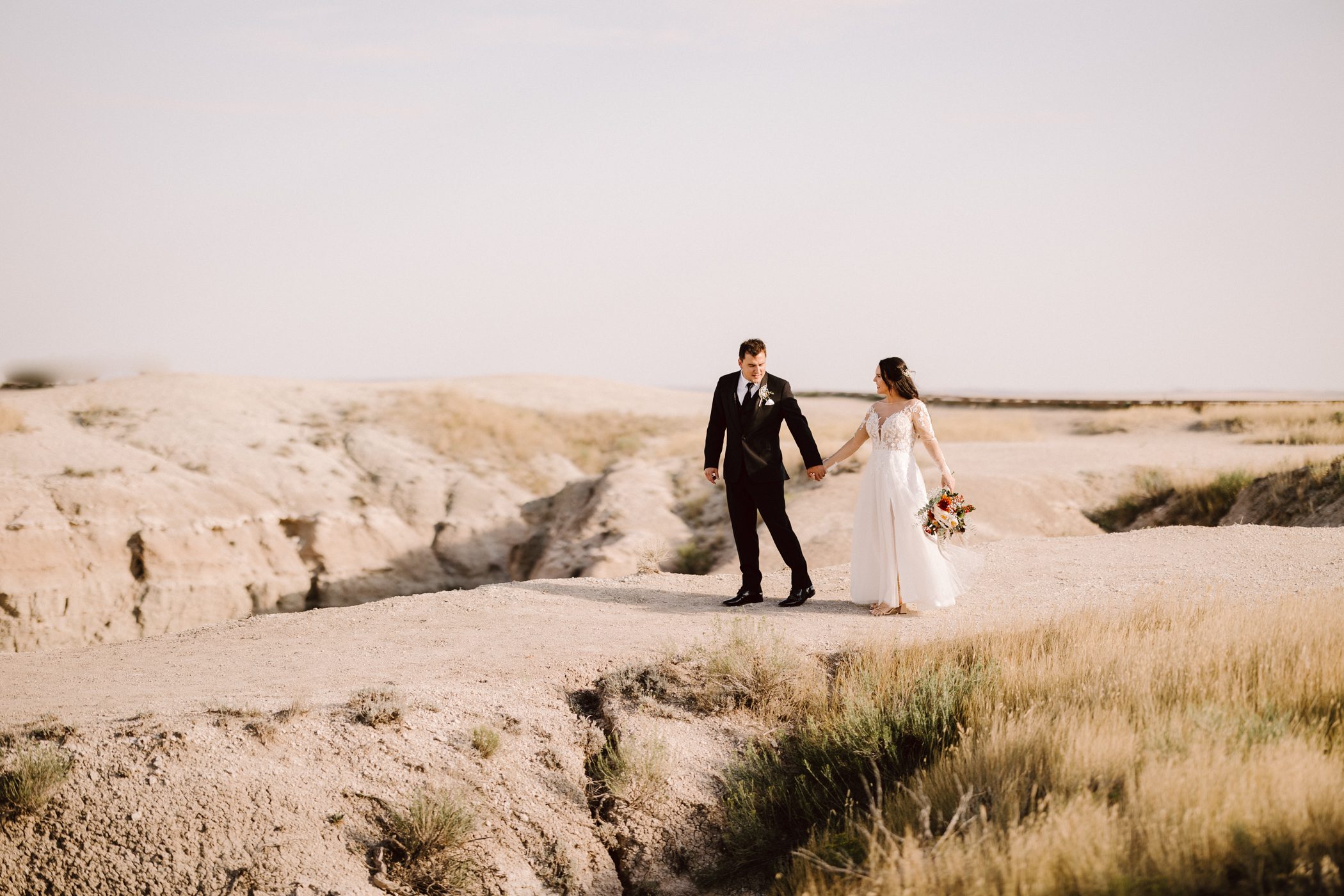 Wide-angle shot of a couple eloping in Badlands National Park with breathtaking landscapes.