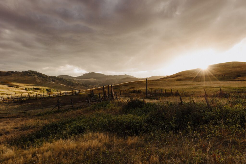 A mountainous scene with the sun about to set on the hillside in Montana
